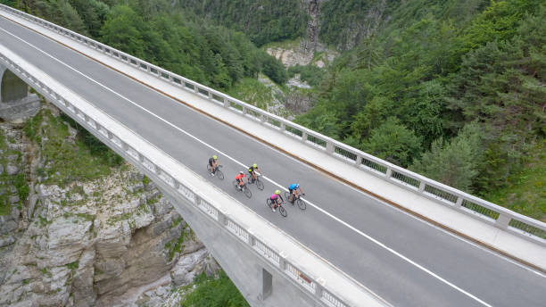 istock Five men and women riding road bikes on bridge 1069941308