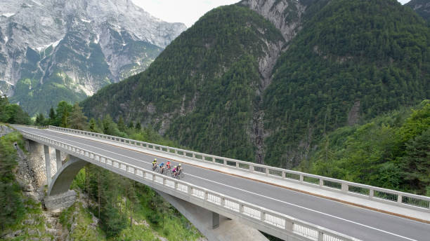 istock Five men and women riding road bikes on bridge 1069941310