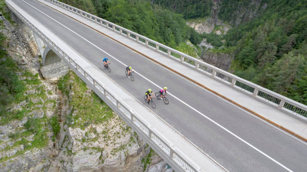 istock Four men and women riding road bikes on bridge 1069941318