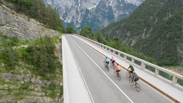 istock Five men and women riding road bikes on bridge 1069941322