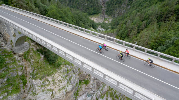istock Five men and women riding road bikes on bridge 1069941330