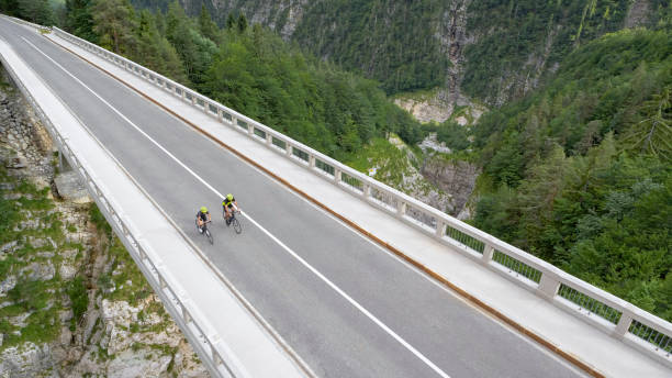 istock Two men riding road bikes on bridge 1069941334