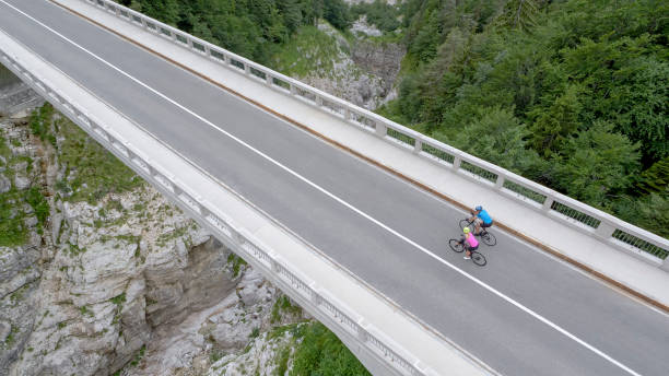 istock Man and woman riding road bikes on bridge 1069941338