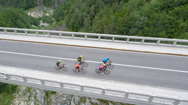 istock Five men and women riding road bikes on bridge 1069941342