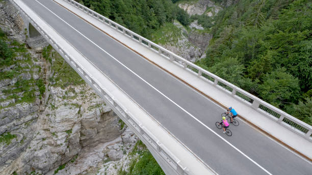 istock Man and woman riding road bikes on bridge 1069941346