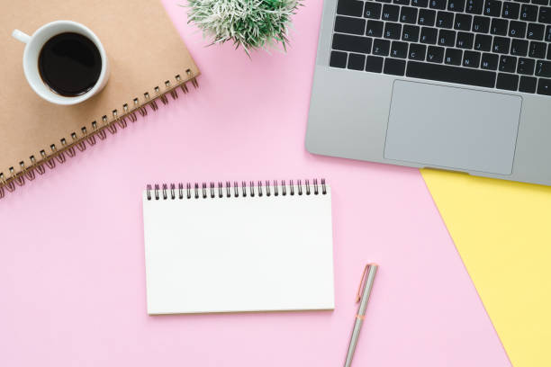 istock Creative flat lay photo of workspace desk. Top view office desk with laptop, blank empty notebooks and coffee cup on pastel color background. Top view with copy space, flat lay photography. 1069943134