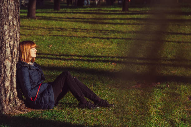 istock The girl sits on a green lawn 1069945992