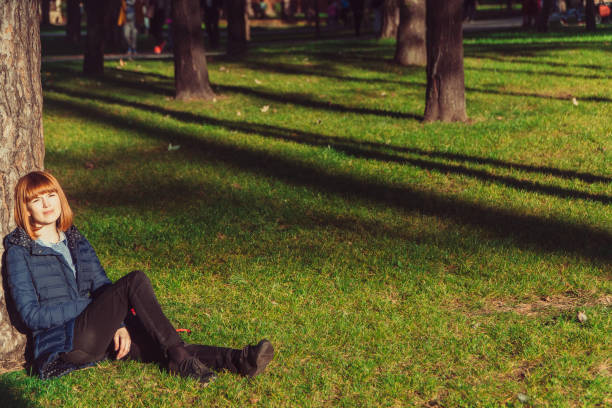 istock The girl sits on a green lawn 1069946208