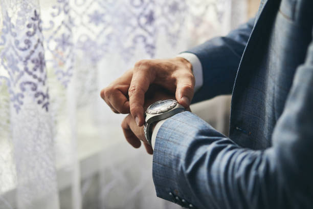 istock businessman checking time on his wrist watch, man putting clock on hand,groom getting ready in the morning before wedding ceremony 1069948672
