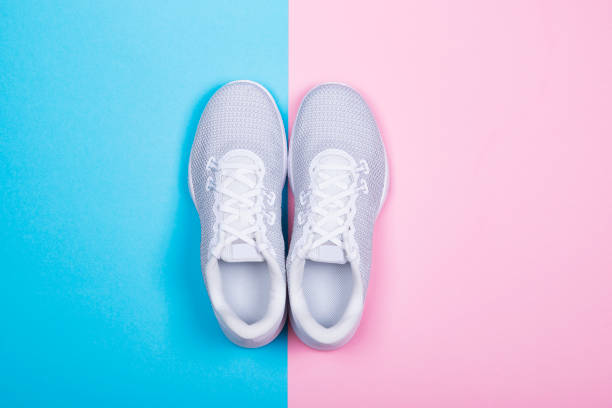 istock White sneakers on blue and pink background. 1069948770