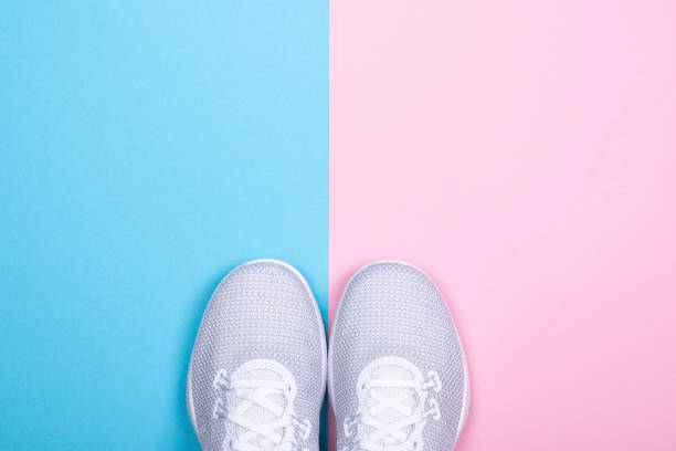 istock White sneakers on blue and pink background. 1069948774