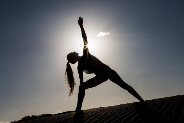 istock Woman doing yoga pose in back lit 1069949468