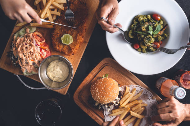 istock Restaurant table with a Fish and Chips, Hamburger and Fries, Pasta 1069950024