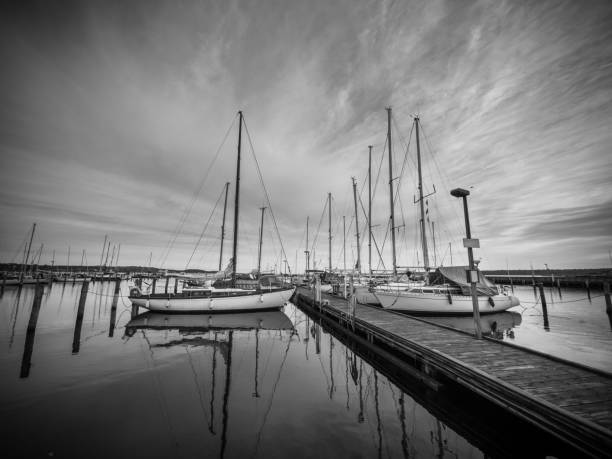 bild einer marina mit wasserreflexion und dramatischen himmel. - motorboat fishing cruise ship dawn stock-fotos und bilder