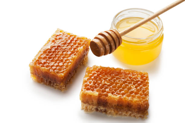 istock Jar full of fresh honey and honeycombs isolated on white 1069952332