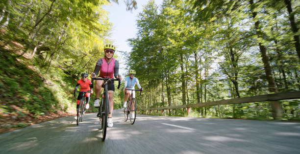 Three women riding road bikes on mountain road