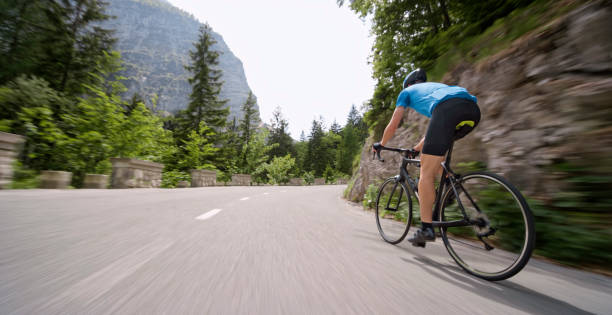 istock Man riding road bike on mountain road 1069952836
