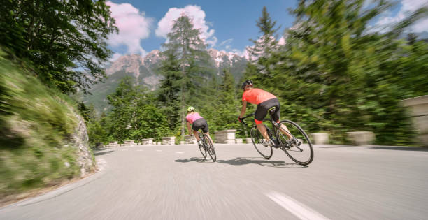 Two women riding road bikes on mountain road