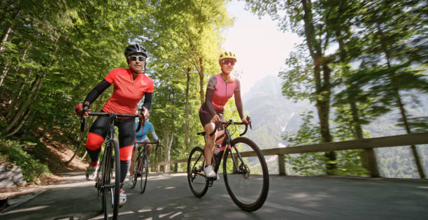 산악도로에로 자전거를 타고 세 여성 - bicycle gear bicycle cycling red 뉴스 사진 이미지