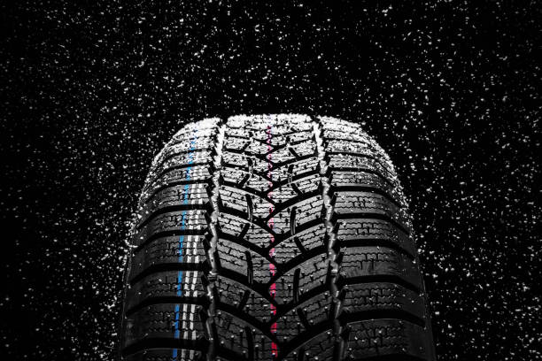 istock Winter Car tires with snow on black background. 1069953640