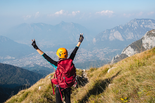 Mountaineer woman with open arms on top mountain