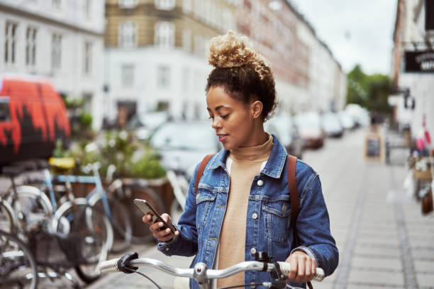 op zoek naar fietswinkels in de buurt - woman on phone stockfoto's en -beelden