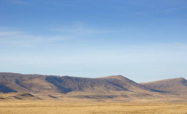 istock Autumn landscape with smooth hills covered with dry yellow grass under blue sky 1069962490