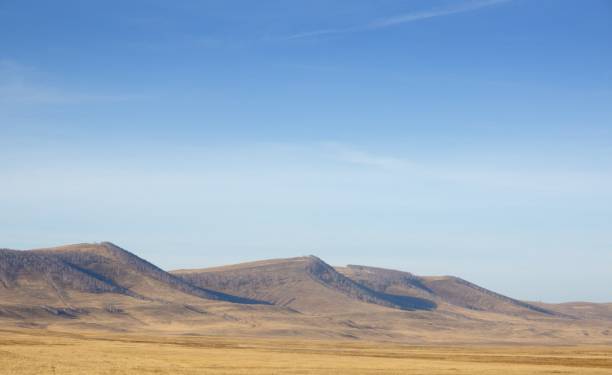 istock Autumn landscape with smooth hills covered with dry yellow grass under blue sky 1069962496