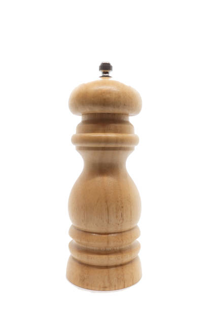 Side view of a pair of salt and pepper mills in contrasting colors, placed on a wooden table in natural sunlight, creating a minimalist and modern aesthetic with vibrant highlights.