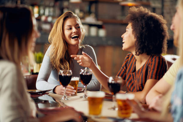 amigos multiculturales pasar buen rato en el restaurante. - dining people women wine fotografías e imágenes de stock