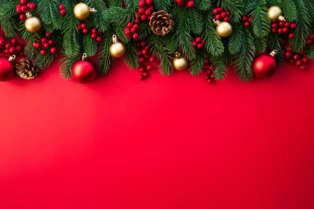 istock Christmas background concept. Top view of Christmas gift box red sock with spruce branches, pine cones, red berries and bell on red background. 1069969002
