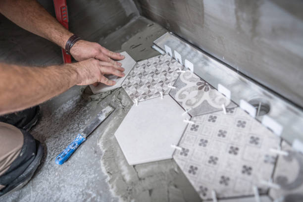 istock Tiler installing ceramic tiles on the bathroom floor 1069971768