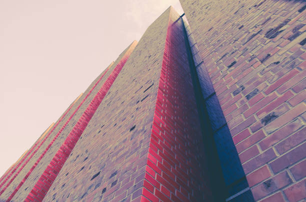 Modern architecture - high clinker brick walls with nooks in the morning light - a part of a skyscraper seen upwards