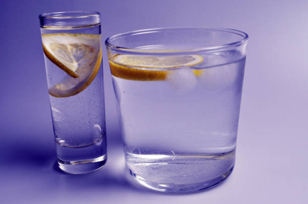 istock two transparent glasses with colorless liquid - water, alcohol 1069974272
