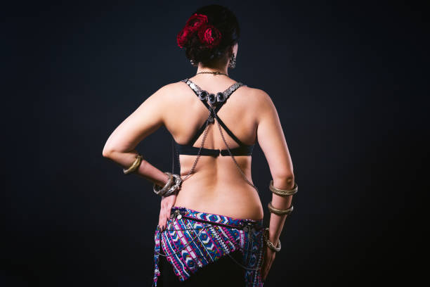 istock Women performs belly dance in ethnic dress on black background 1069975766