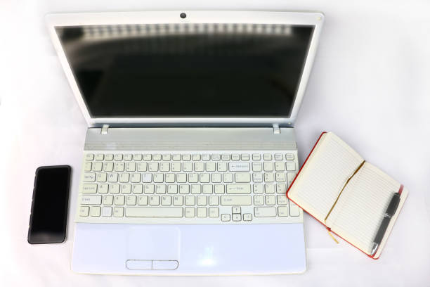 istock white laptop, smartphone and diary with pen on a light background 1069977942