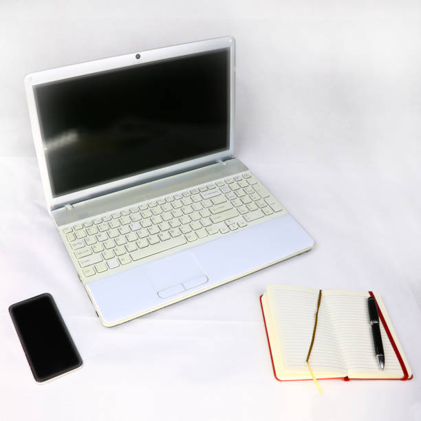 istock white laptop, smartphone and diary with pen on a light background 1069977946