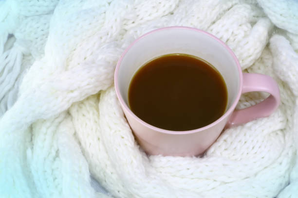 istock a cup of coffee wrapped in a woolen white scarf 1069978156