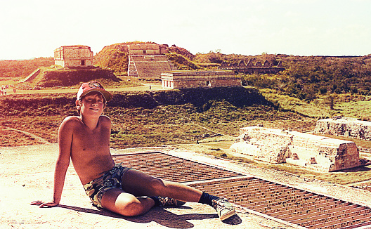 Vintage image of a boy at the pre-colombian ruins of Uxmal,Mexico.