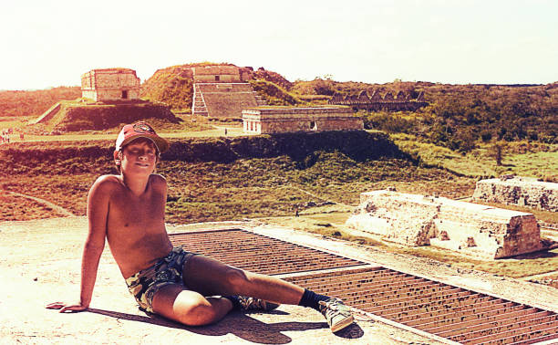 Vintage boy in a visit to the mayan ruins in Mexico Vintage image of a boy at the pre-colombian ruins of Uxmal,Mexico. yucatan photos stock pictures, royalty-free photos & images