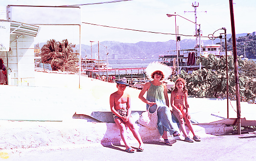Vintage image of a mother and her children in a little mexican town during a summer vacation in the seventies.