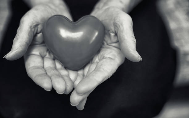 istock elder woman holding heart 1069982438
