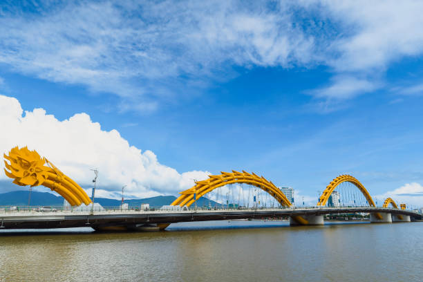 Dragon Bridge A wide-view shot of the dragon bridge in Da Nang, Vietnam. Vehicles can be seen crossing over the bridge which stands over the Han​ river. central vietnam stock pictures, royalty-free photos & images