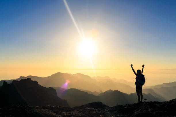 istock Woman hiking success silhouette in mountains sunset 1069988708