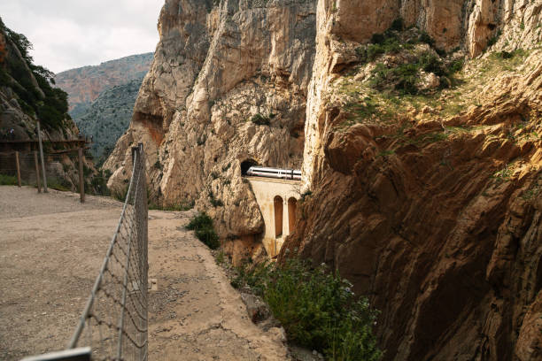 istock A train crossing a tunnel between hills over a stone bridge 1069993710