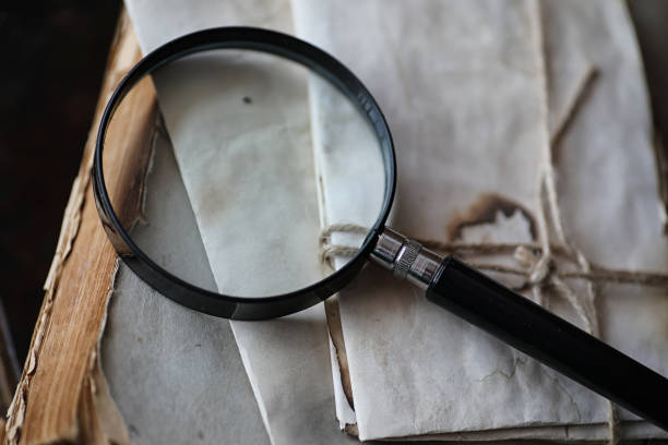 istock Old books on a wooden table and magnifier 1069993928