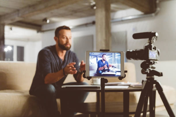 jeune homme faire un blog vidéo - studio equipment photos et images de collection