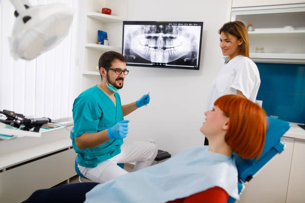 istock Young woman at dentist's office looking at X-ray image 1069996938
