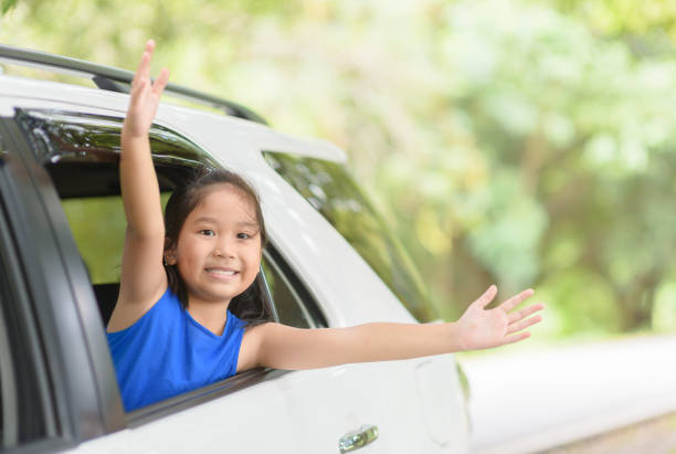 istock Happy kid with raised arms from window car 1070002370
