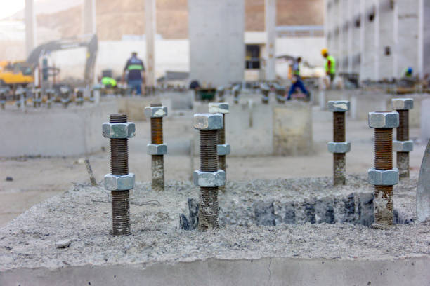 the anchor bolts in the  concrete foundation of the new industrial plant. these anchors for structural steel construction. - construction steel construction frame built structure imagens e fotografias de stock